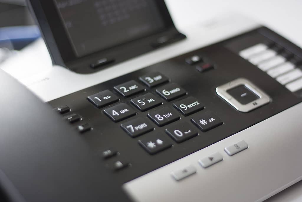 Black and grey desk phone with a screen.